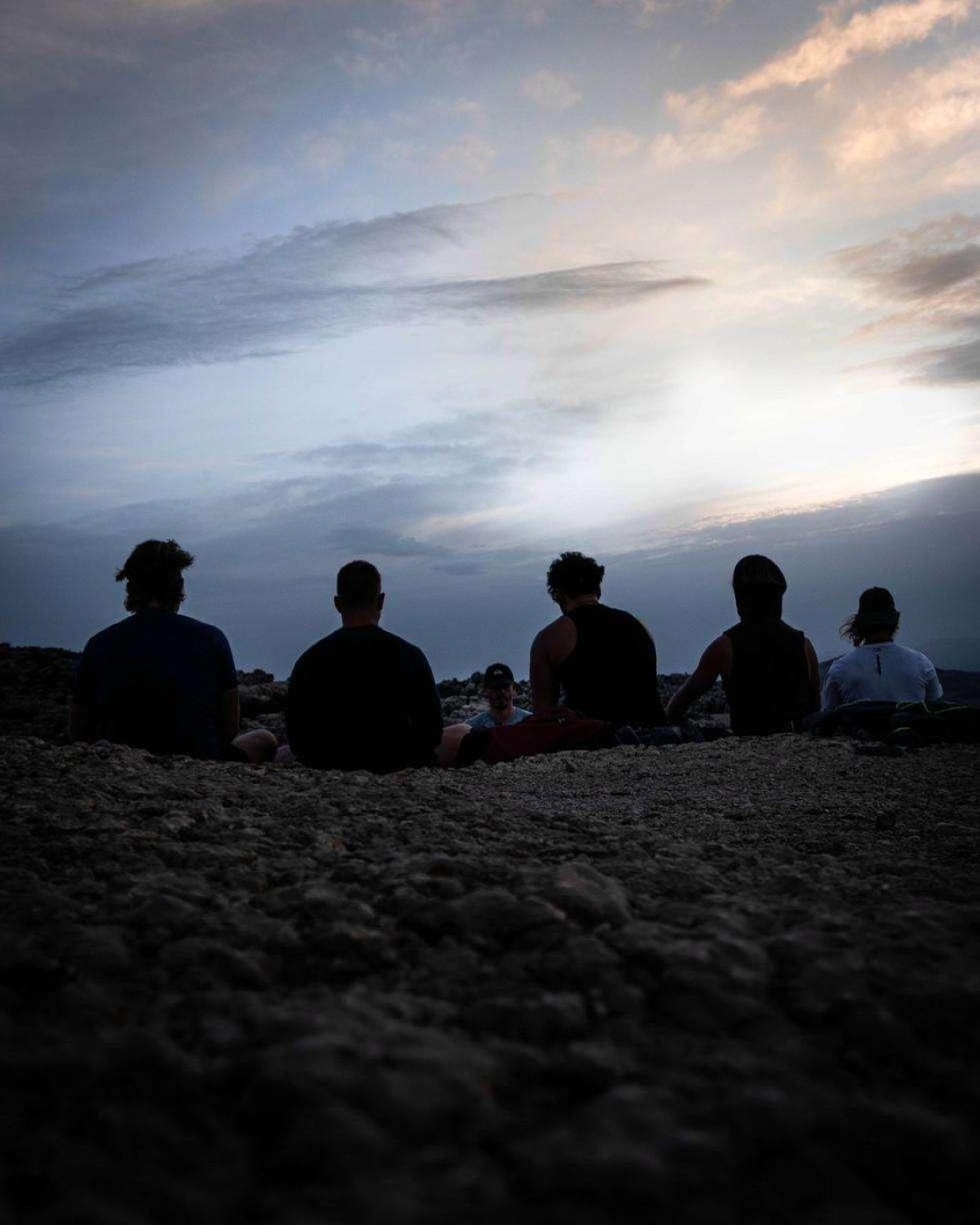The group watching the sky from the summit at dusk