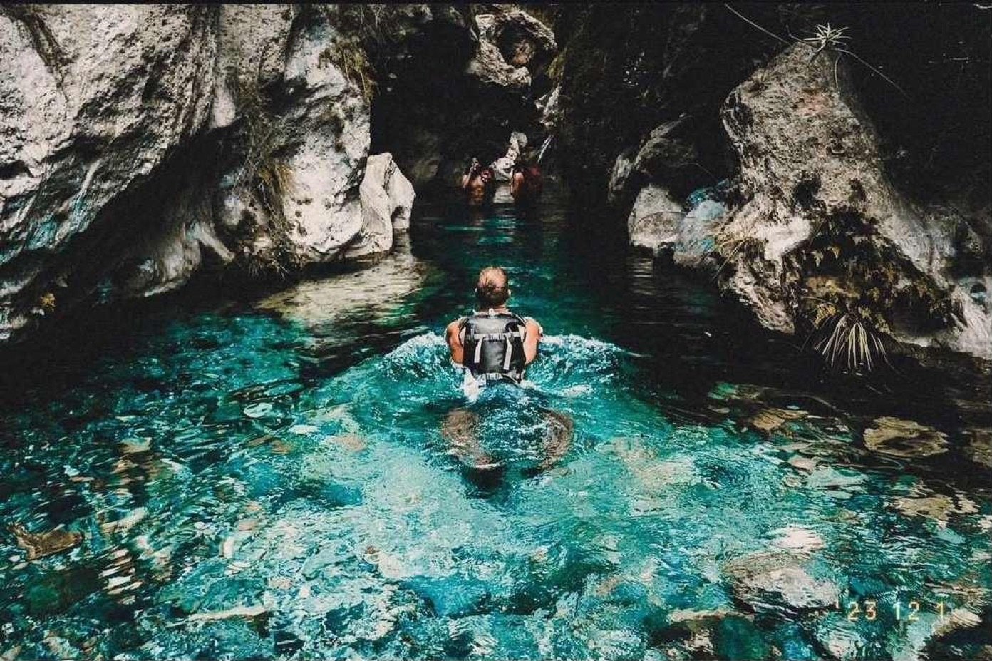 A swimmer in a turquoise mountain pool